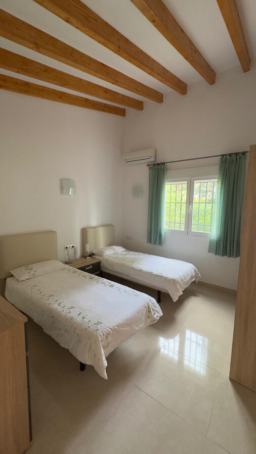 Dormitorio con dos camas individuales y armario